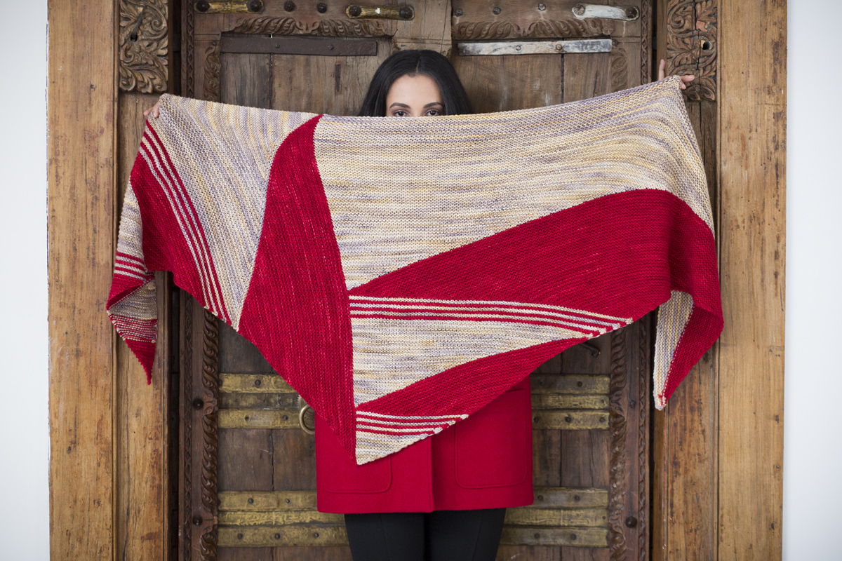 woman holding hand knitted red shawl